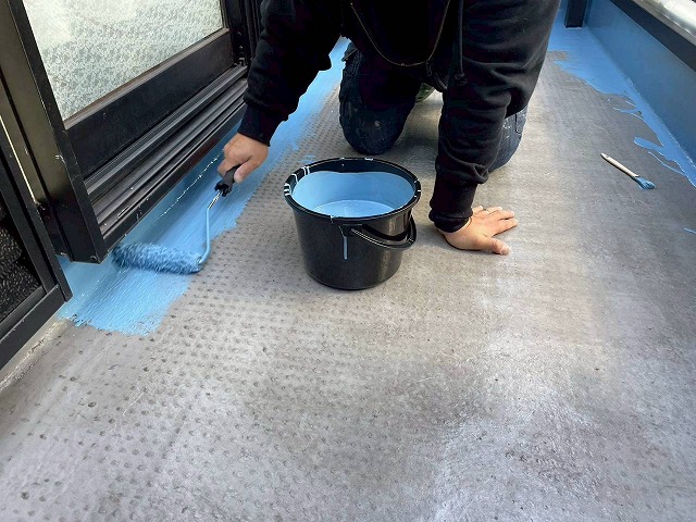 明石市のベランダで防水塗料をていねいに塗り進める